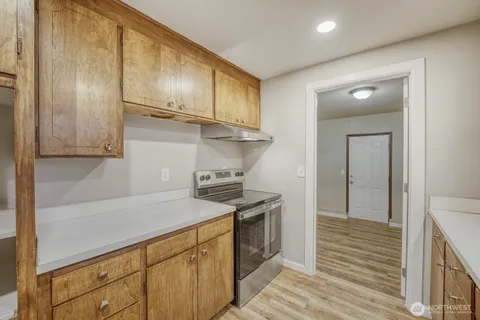 a kitchen with stainless steel appliances granite countertop a sink a stove and a refrigerator