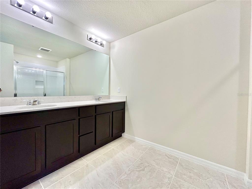 4652 Sparkling Shell Avenue Kissimmee, FL 34746 - Photo 22 of 35 a bathroom with a double vanity sink and a mirror