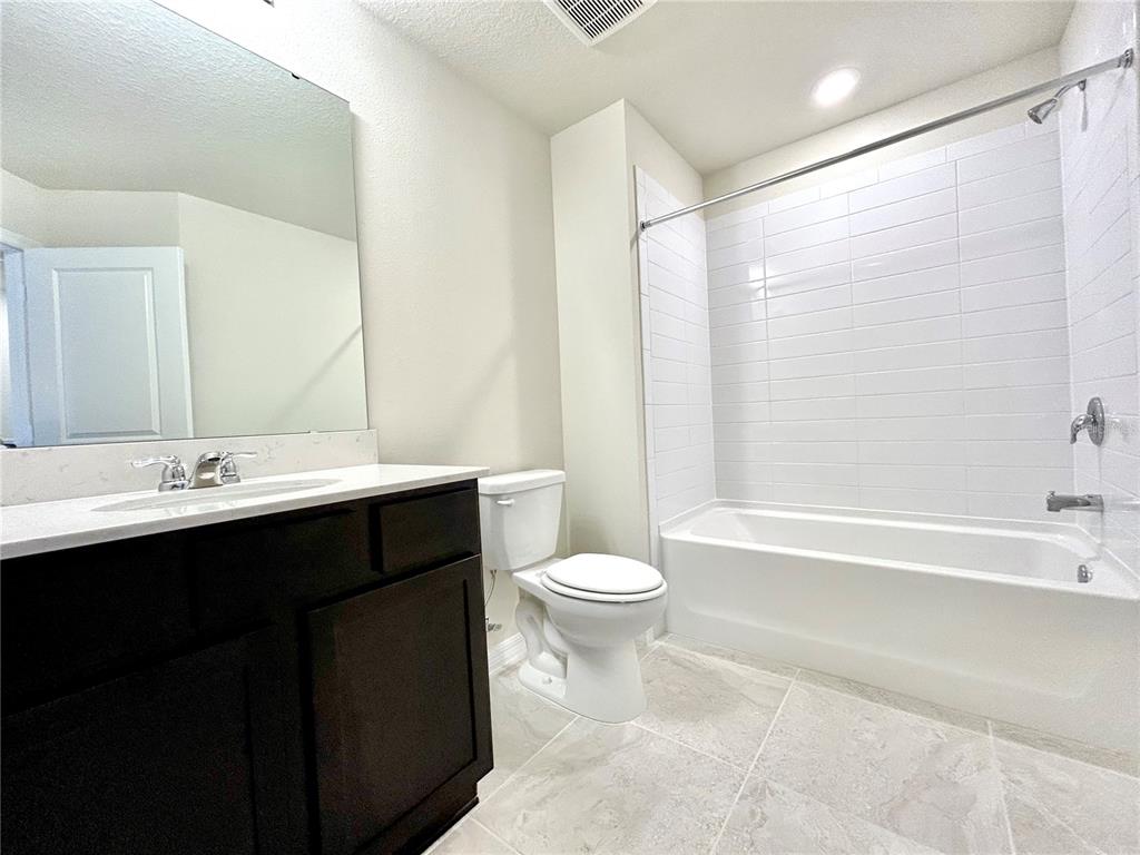 4652 Sparkling Shell Avenue Kissimmee, FL 34746 - Photo 23 of 35 a bathroom with a double vanity sink toilet and shower