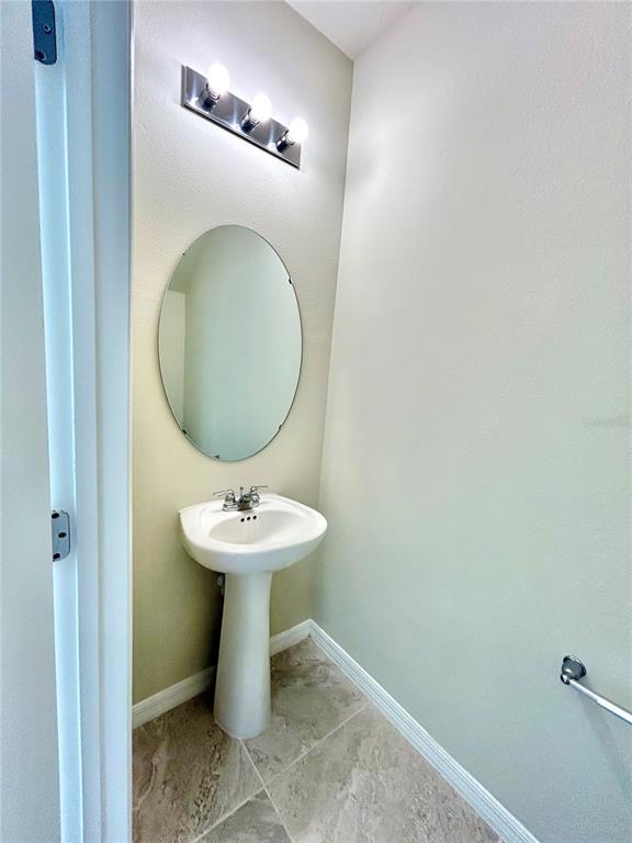4652 Sparkling Shell Avenue Kissimmee, FL 34746 - Photo 24 of 35 a bathroom with a sink mirror and toilet