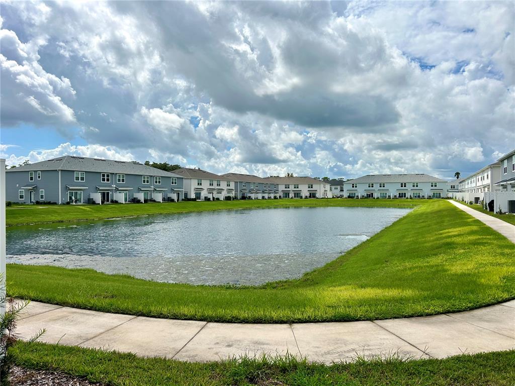 4652 Sparkling Shell Avenue Kissimmee, FL 34746 - Photo 29 of 35 a view of a lake with a big yard and large trees