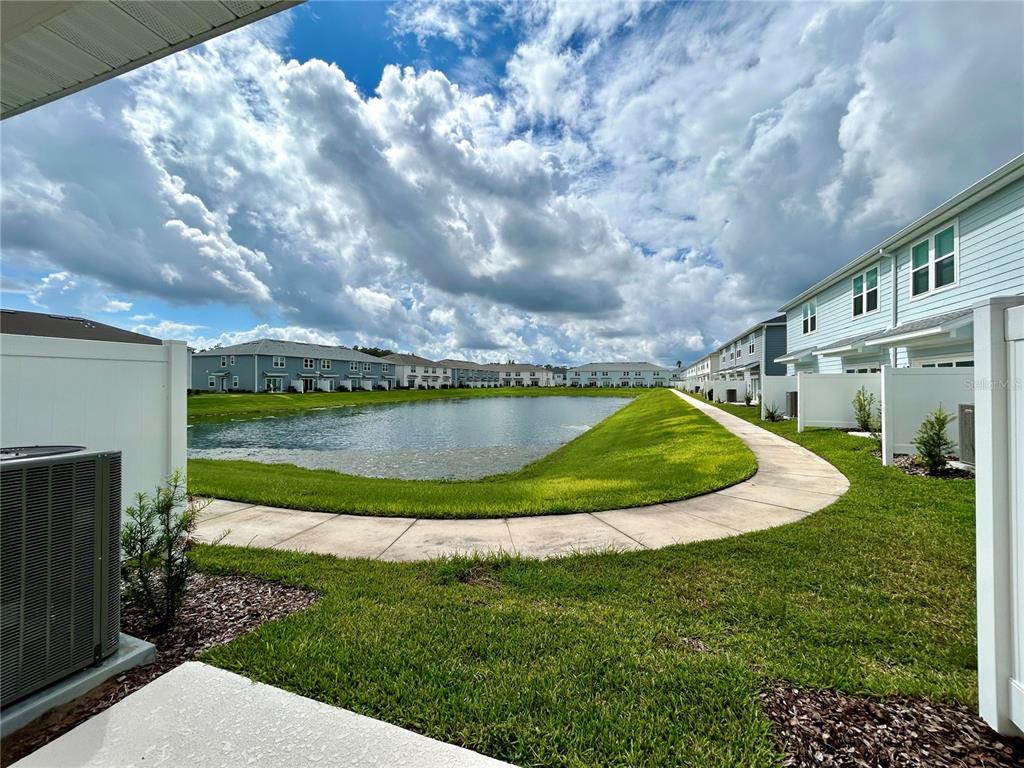4652 Sparkling Shell Avenue Kissimmee, FL 34746 - Photo 30 of 35 a view of a house with a big yard potted plants and large tree