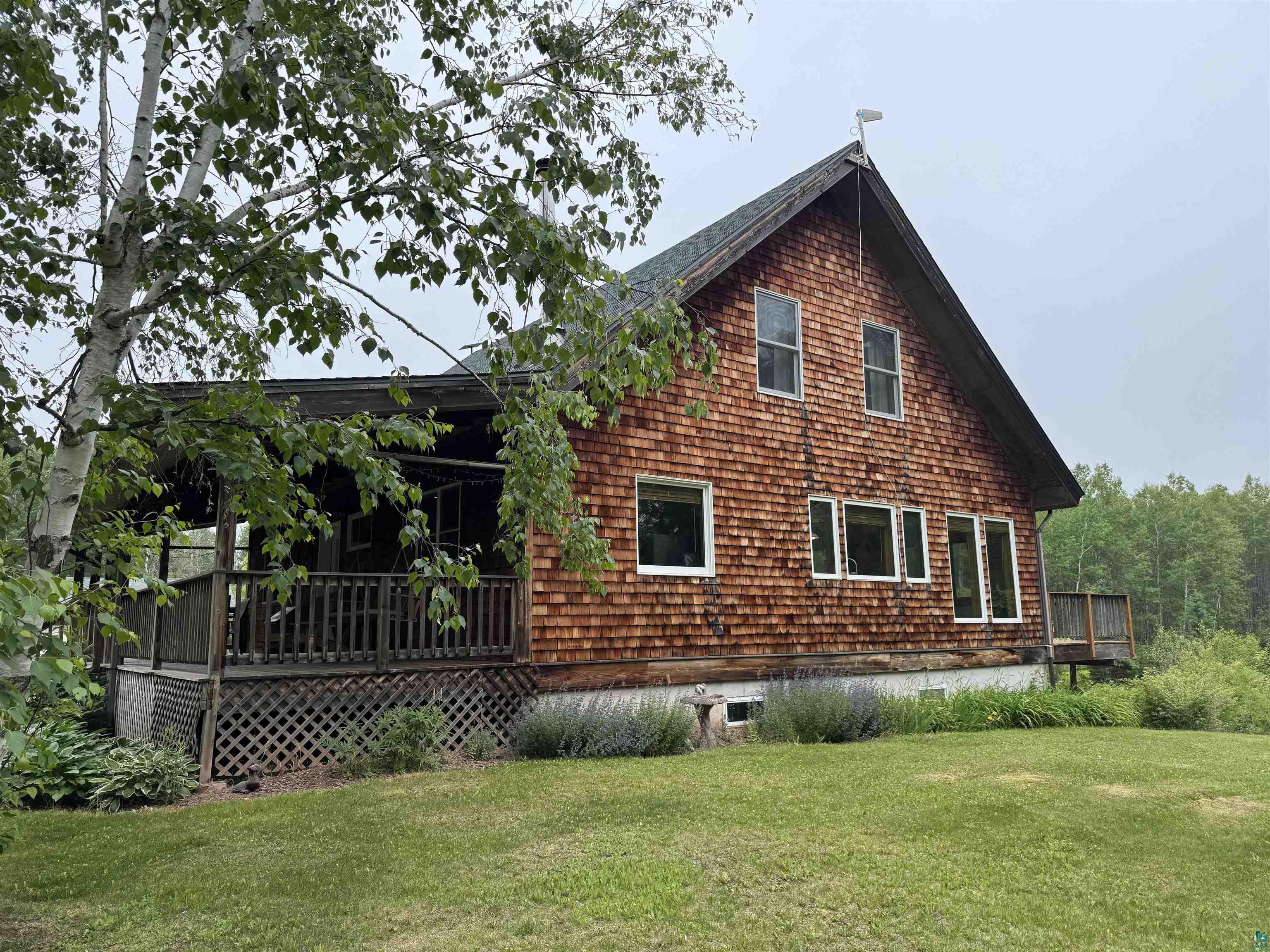 1745 Becks Road Maple, WI 54854 - Photo 4 of 46 Cedar shake siding exterior featuring a covered porch, a side deck, multiple windows, and a prominent gable roofline