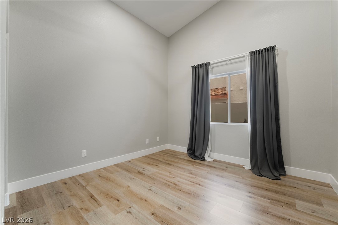9171 West Viking Road Las Vegas, NV 89147 - Photo 24 of 43 Natural wood flooring complements the window-lit room, ideal for flexible use.