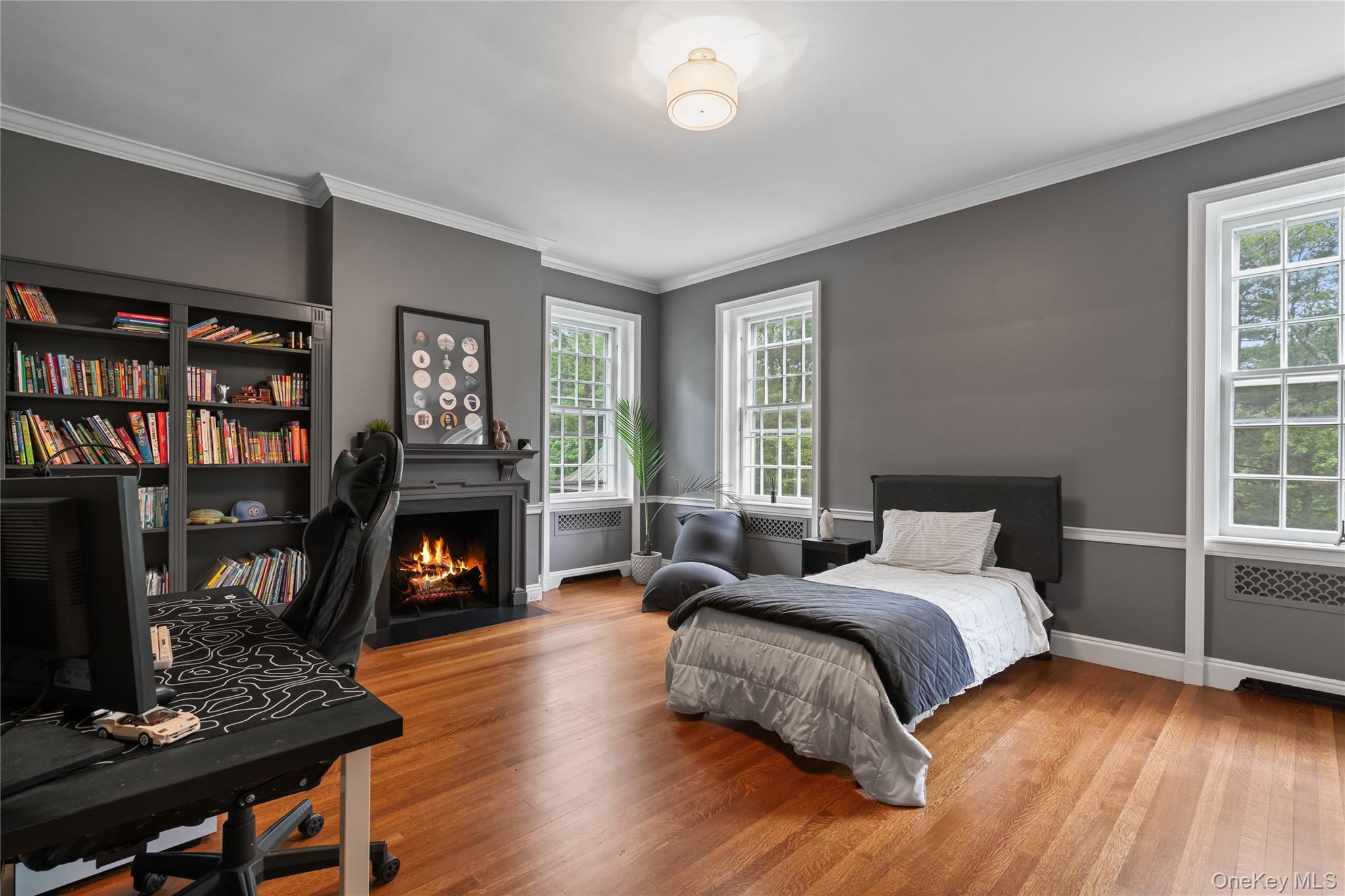 88 Wheatley Road Old Westbury, NY 11568 - Photo 27 of 40 Bedroom with wood finished floors, ornamental molding, a fireplace with flush hearth, and multiple windows