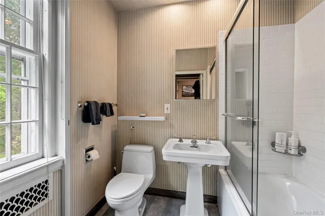 a bathroom with a toilet a sink and mirror