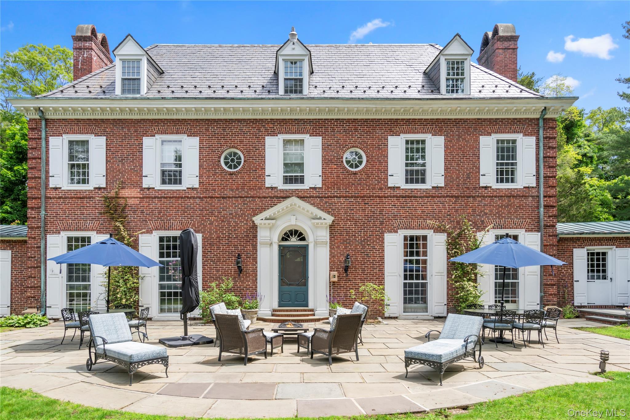 88 Wheatley Road Old Westbury, NY 11568 - Photo 33 of 40 Back of property featuring a patio, a high end roof, and a chimney