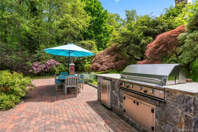 a view of a patio with a dining table and chairs under an umbrella
