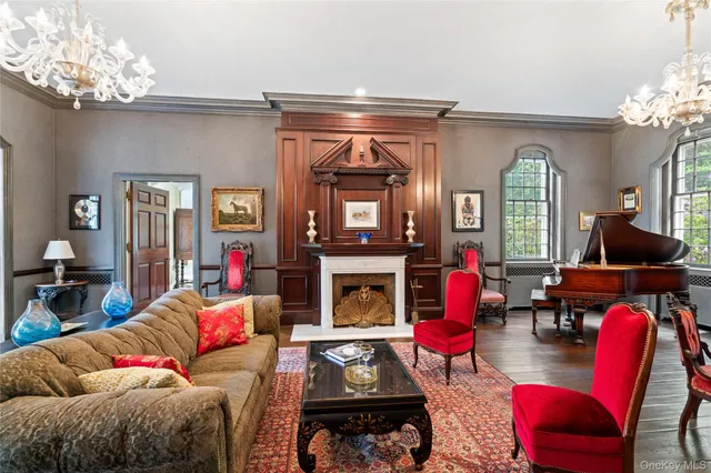 a living room with furniture a fireplace and a chandelier