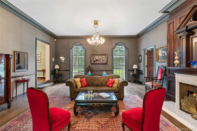 a living room with furniture a fireplace and a chandelier