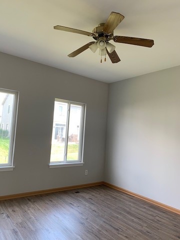 707 Shannon Drive Romeoville, IL 60446 - Photo 6 of 14 a view of an empty room with wooden floor and a window