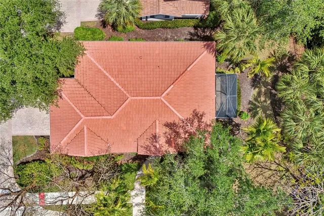 an aerial view of a house with a yard and large trees