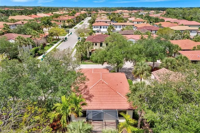 an aerial view of residential houses with outdoor space and trees