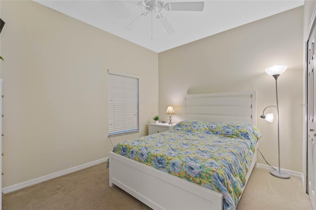 8535 Bay Lilly Loop Kissimmee, FL 34747 - Photo 11 of 57 a bedroom with a bed and a chandelier fan