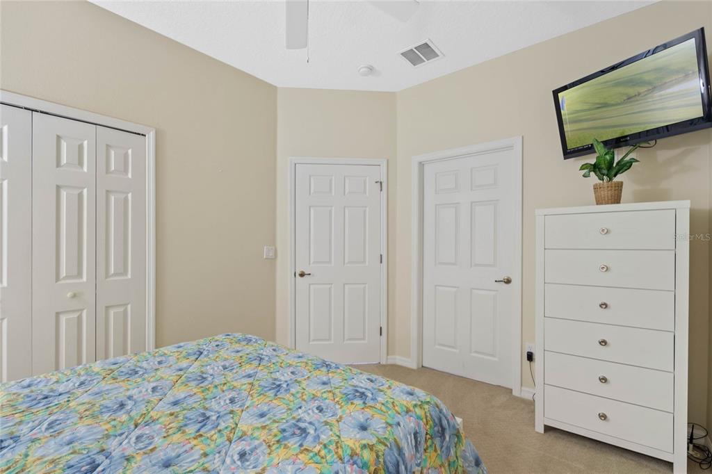 8535 Bay Lilly Loop Kissimmee, FL 34747 - Photo 13 of 57 a bedroom with a bed and a flat screen tv