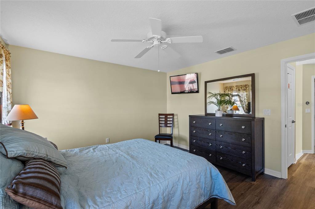 8535 Bay Lilly Loop Kissimmee, FL 34747 - Photo 17 of 57 a bedroom with a bed and a chandelier