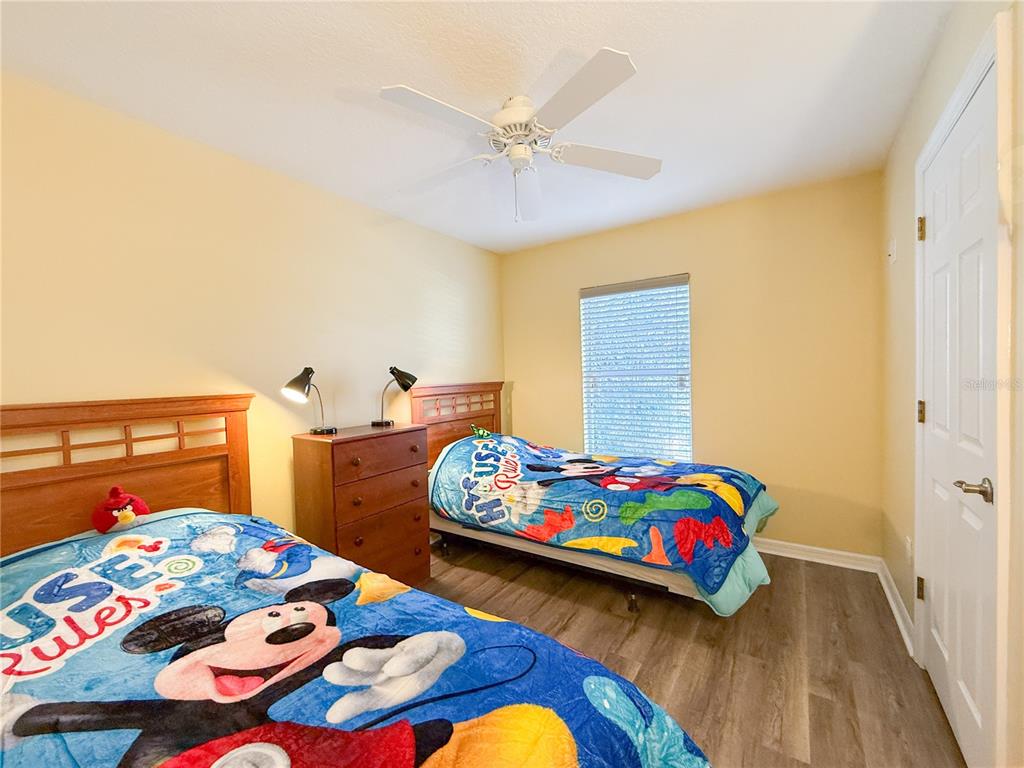 8535 Bay Lilly Loop Kissimmee, FL 34747 - Photo 20 of 57 a bedroom that has a bed and a table in it