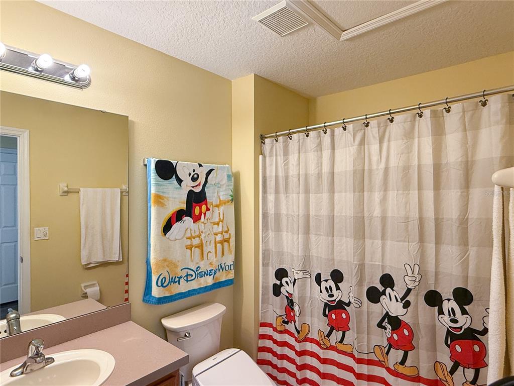 8535 Bay Lilly Loop Kissimmee, FL 34747 - Photo 23 of 57 a bathroom with a sink a toilet and shower curtain