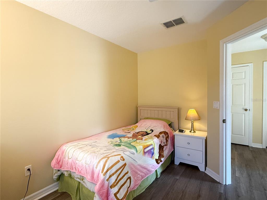 8535 Bay Lilly Loop Kissimmee, FL 34747 - Photo 24 of 57 a bedroom with a bed and wooden floor