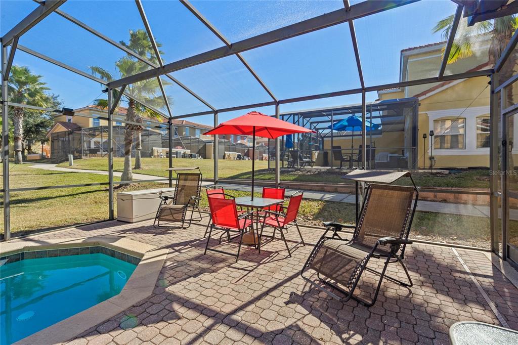 8535 Bay Lilly Loop Kissimmee, FL 34747 - Photo 28 of 57 a view of a patio with table and chairs under an umbrella