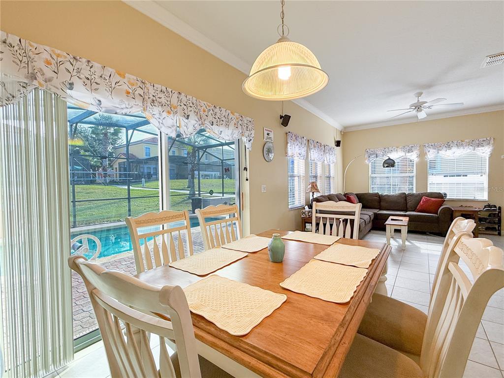 8535 Bay Lilly Loop Kissimmee, FL 34747 - Photo 4 of 57 a view of a dining room with furniture a chandelier and large windows