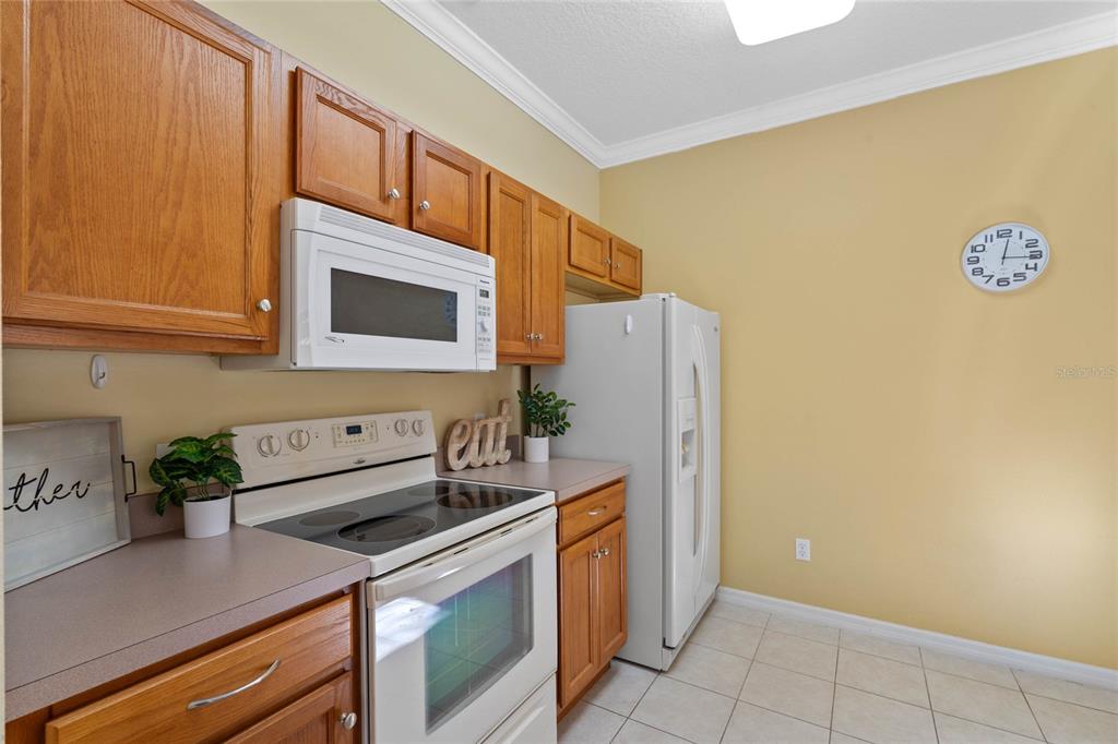 8535 Bay Lilly Loop Kissimmee, FL 34747 - Photo 8 of 57 a kitchen with stainless steel appliances a refrigerator a stove a sink and a microwave