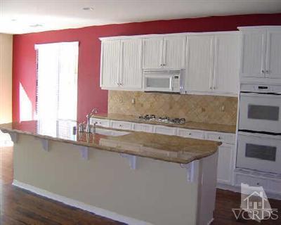 1497 Hidden Ranch Drive Simi Valley, CA 93063 - Photo 3 of 9 a kitchen with granite countertop a sink a stove and a microwave