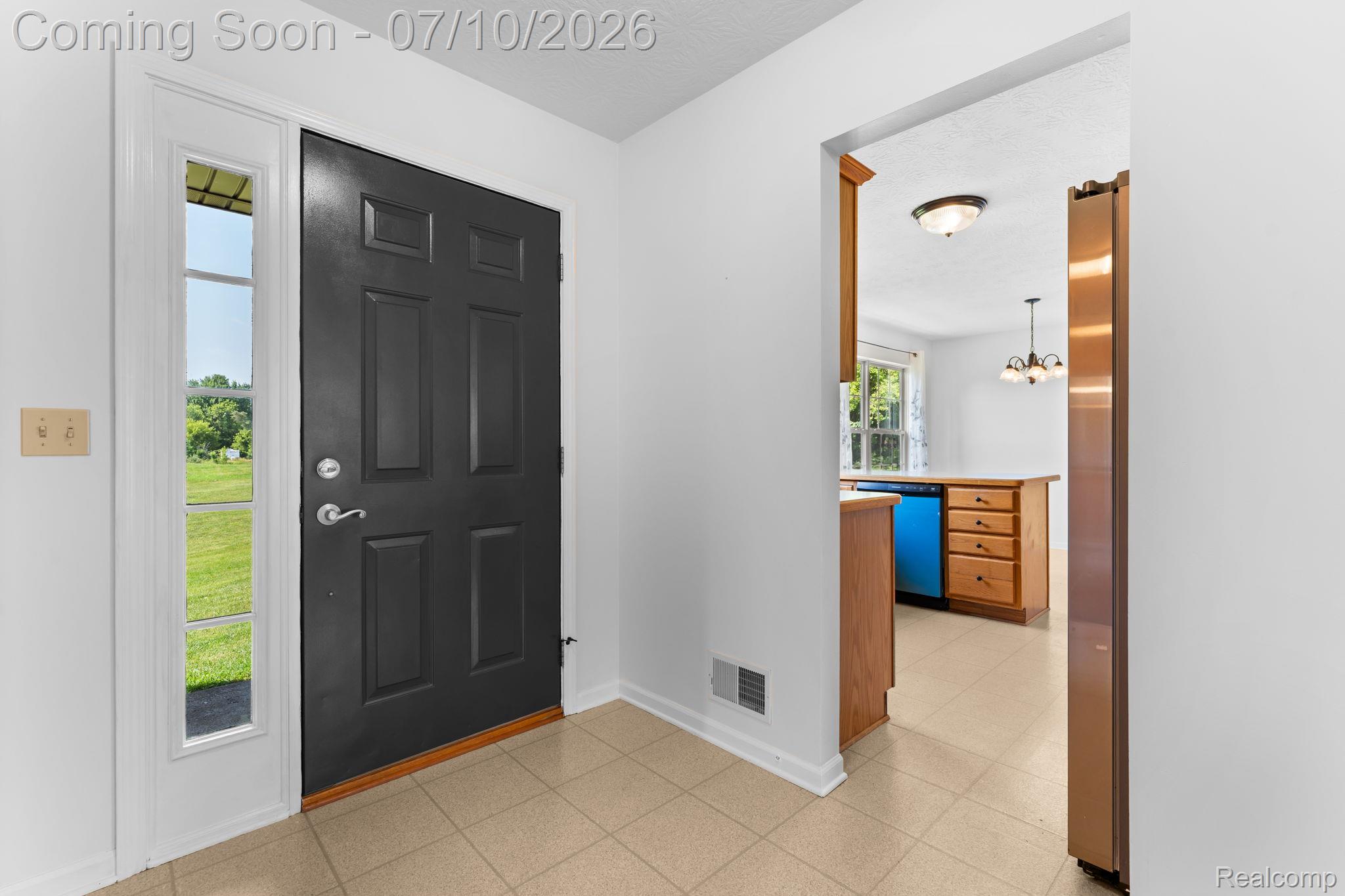 3144 North Nicholson Road Fowlerville, MI 48836 - Photo 31 of 70 Entryway featuring a paneled black door, sidelight window, and tile flooring