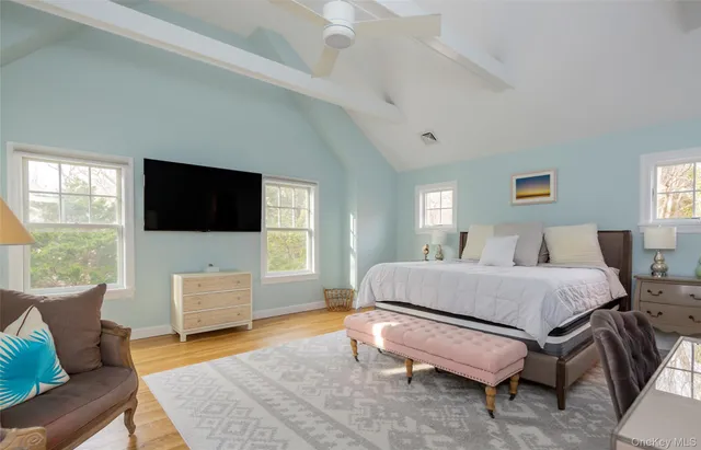 a living room with furniture a flat screen tv and a window