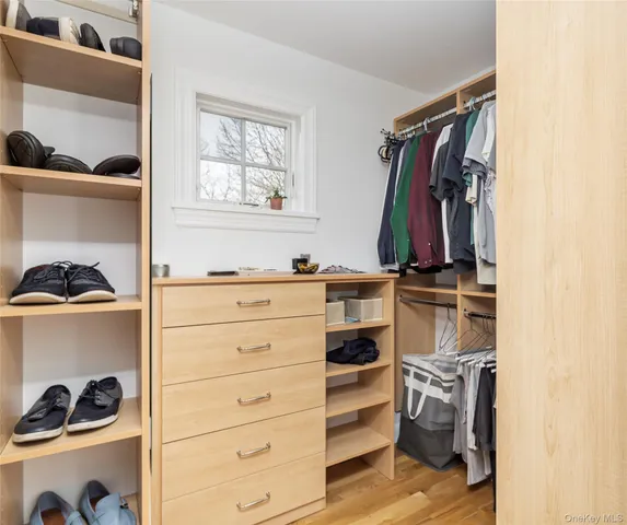 a view of walk in closet with clothes and shoes