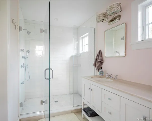 a bathroom with a shower sink and mirror