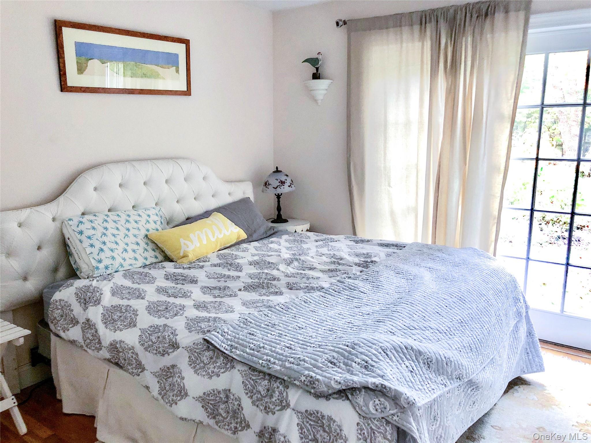 10 Deer Path East Hampton, NY 11937 - Photo 22 of 35 a bedroom with a bed and a window
