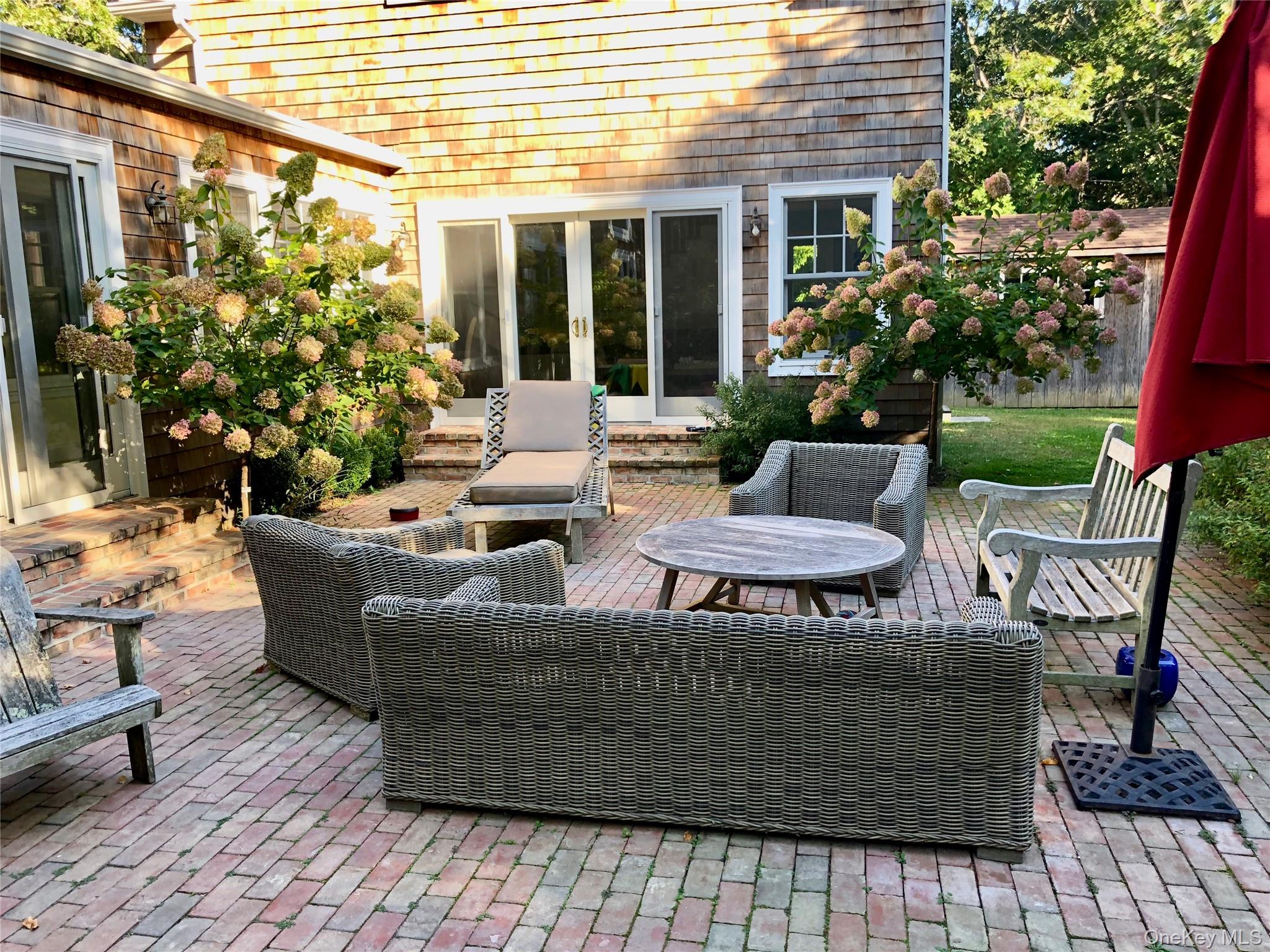 10 Deer Path East Hampton, NY 11937 - Photo 31 of 35 a view of a patio with couches table and chairs and potted plants