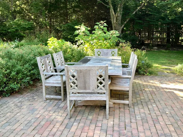 a view of a chairs and table in patio with a yard