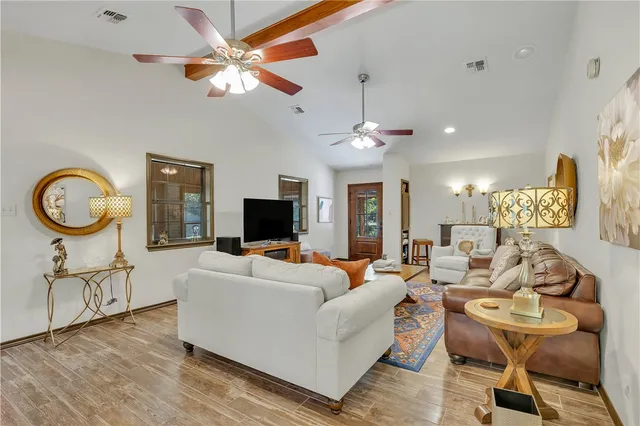 a living room with furniture kitchen view and a flat screen tv