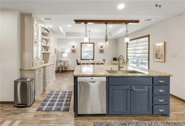 a room with stainless steel appliances kitchen island granite countertop furniture and a large window