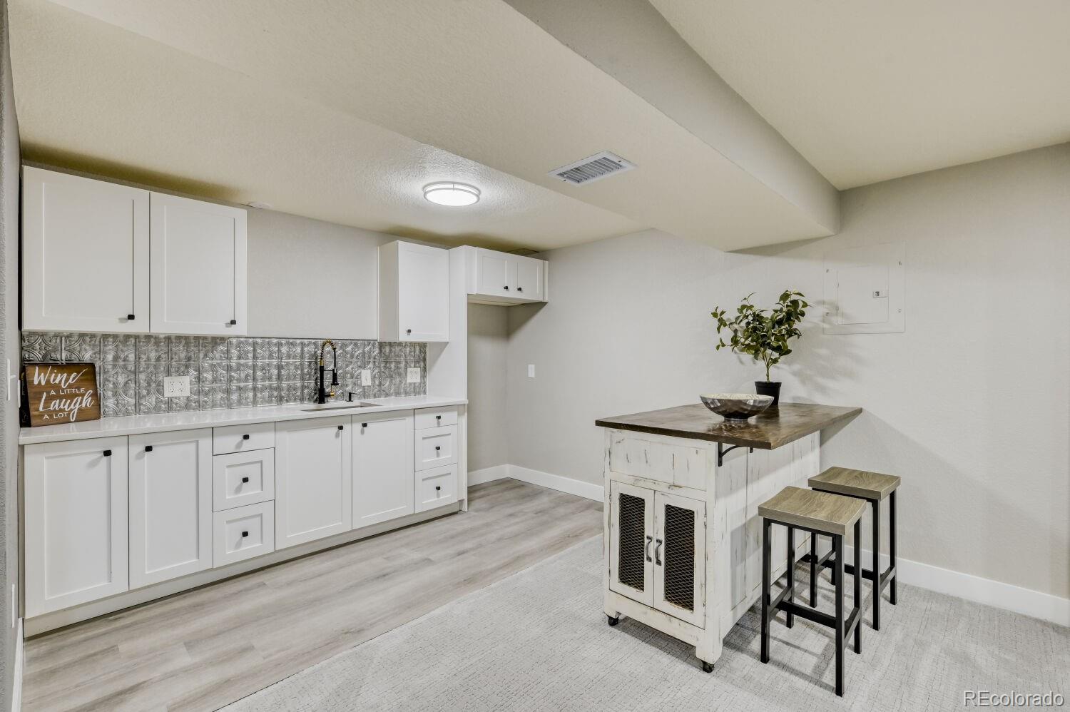6623 Kipling Street Arvada, CO 80004 - Photo 27 of 39 a kitchen with granite countertop white cabinets and window