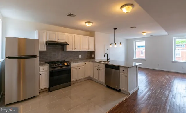 a kitchen with granite countertop a refrigerator stove top oven and sink