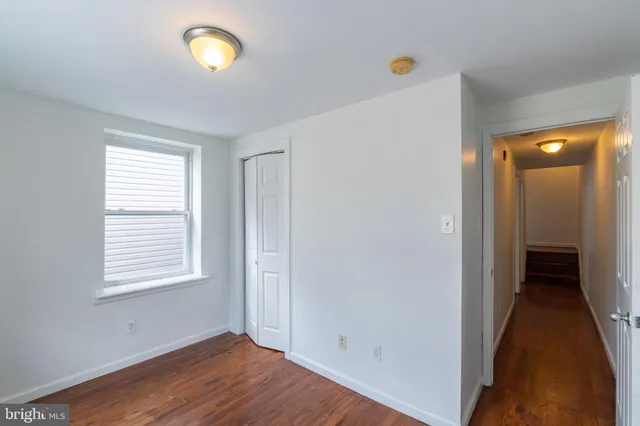 a view of an empty room with closet and a window