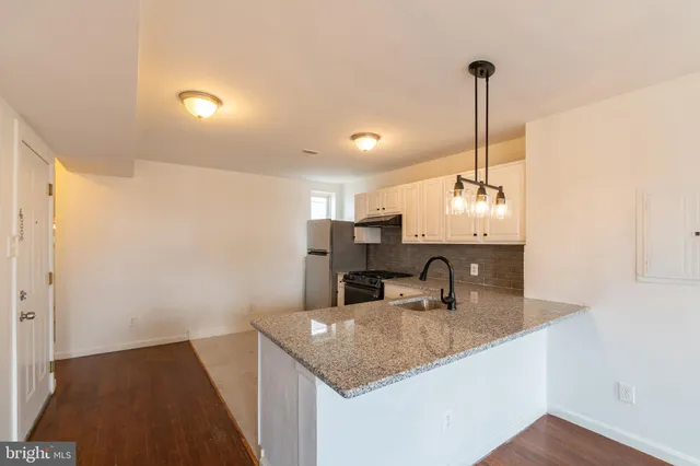 a kitchen with kitchen island a sink stainless steel appliances and a counter top space