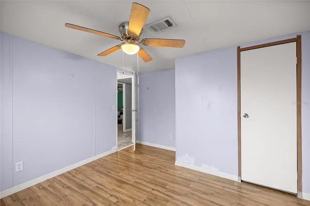 an empty room with a window and ceiling fan