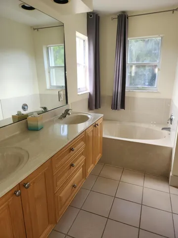 a bathroom with a tub sink and mirror