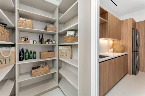 a kitchen with stainless steel appliances a sink dishwasher and a refrigerator with wooden cabinets