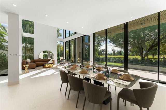 a dining room with furniture and a large window