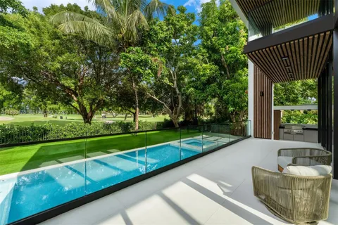 an aerial view of residential houses with outdoor space and trees