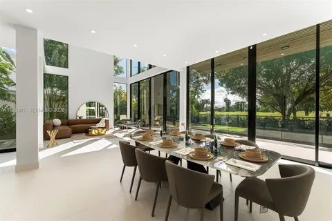 a view of a patio with couches table and chairs and floor to ceiling window