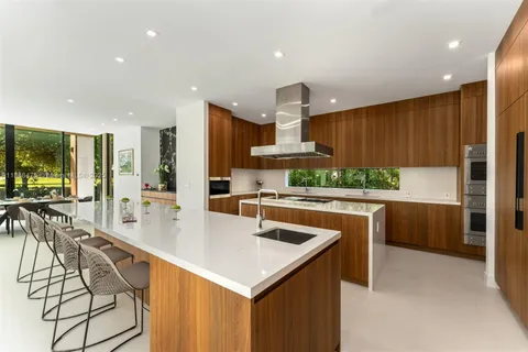a kitchen with stainless steel appliances kitchen island granite countertop a sink a stove and a refrigerator