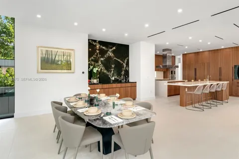a kitchen with granite countertop lots of wooden cabinets stainless steel appliances a large window and a fireplace
