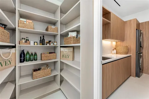 a kitchen with stainless steel appliances a sink dishwasher and a refrigerator with wooden cabinets