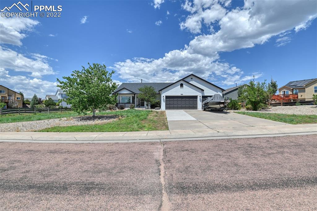 a view of a house with a yard and a garage